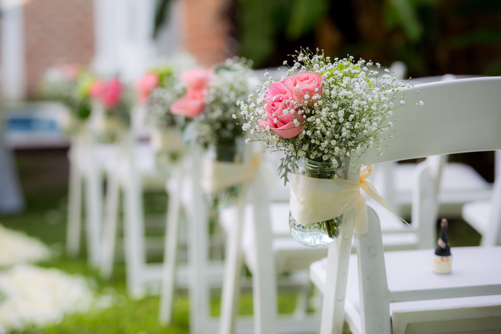 A Row of Wooden Folding Chairs with Flowers 